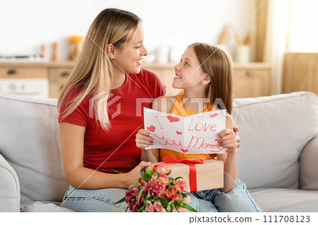 Loving daughter greeting surprised mom with Mother's Day 111708123