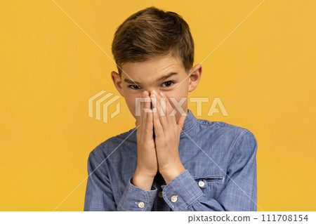 Teen boy with look of disgust pinching nose to avoid bad smell 111708154