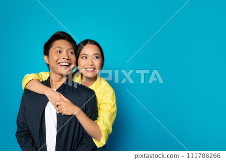 Satisfied millennial korean lady hug guy in casual look at copy space, enjoy relationships 111708266