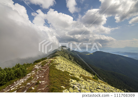 Fantastic panorama view of bright white clouds lit by sun in blue summer sky over mountain ridge. Fantastic panorama view of bright white clouds lit by sun in blue summer sky over mountain ridge. 111708309