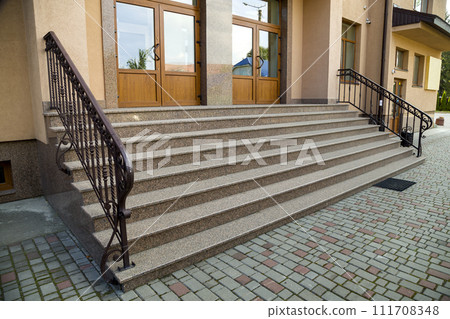 Detail of a house facade. New granite stairs with metal railings. Detail of a house facade. New granite stairs with metal railings. 111708348