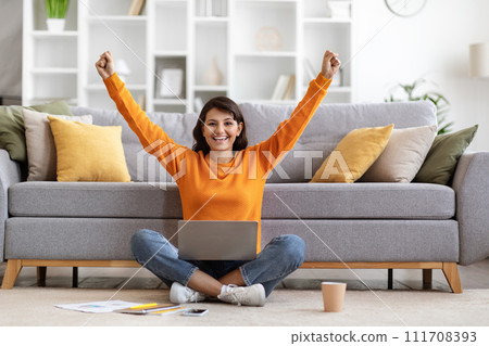 Excited young indian woman with laptop raising hands up Excited young indian woman with laptop raising hands up 111708393
