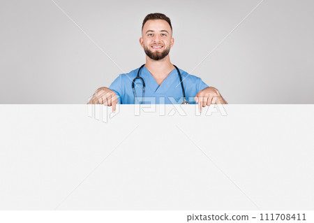 Happy male nurse pointing at a blank banner for text Happy male nurse pointing at a blank banner for text 111708411