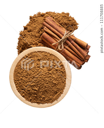 cinnamon sticks and wooden bowl with cinnamon powder isolated on a white background, top view. cinnamon sticks and wooden bowl with cinnamon powder isolated on a white background, top view. 111708885