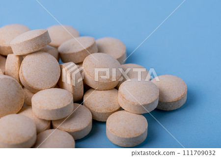 Orange pills vitamin C. pills on blue background. 111709032