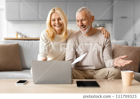 Happy mature man and woman paying bills online 111709323