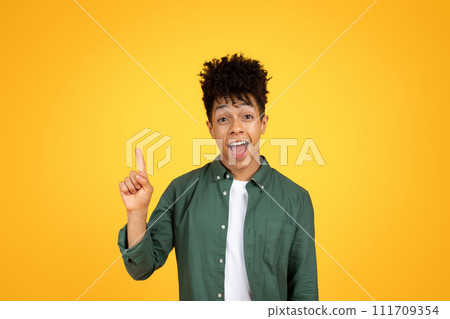 Excited african american guy raising finger up, yellow background Excited african american guy raising finger up, yellow background 111709354