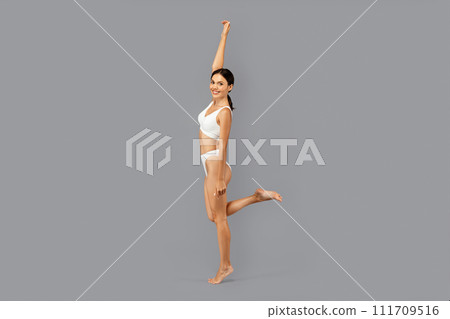 Smiling european slim young lady in underwear with perfect body, enjoy body care Smiling european slim young lady in underwear with perfect body, enjoy body care 111709516