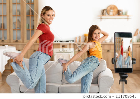 Funny mother and daughter kid dancing recording video on phone 111709543