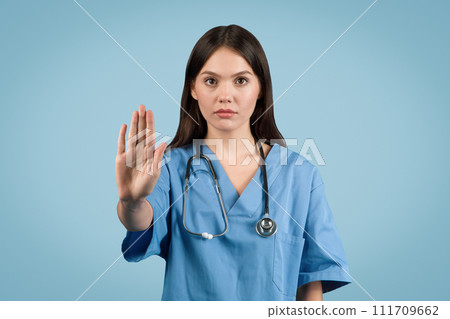 Young European nurse in blue coat signals stop 111709662
