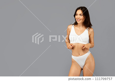 Cheerful european young woman in white sports bra and underwear 111709757