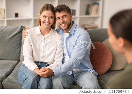 Millennial spouses share hug on couch in psychologist's office Millennial spouses share hug on couch in psychologist's office 111709784