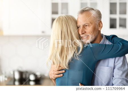 Loving Wife Embracing Her Elderly Husband At Home Loving Wife Embracing Her Elderly Husband At Home 111709964