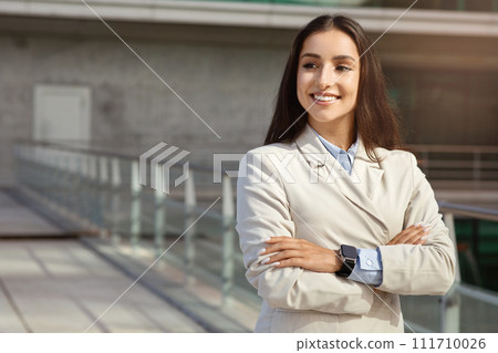 Glad pretty confident millennial lady in suit with smartwatch enjoy work in city with crossed arms on chest Glad pretty confident millennial lady in suit with smartwatch enjoy work in city with crossed arms on chest 111710026
