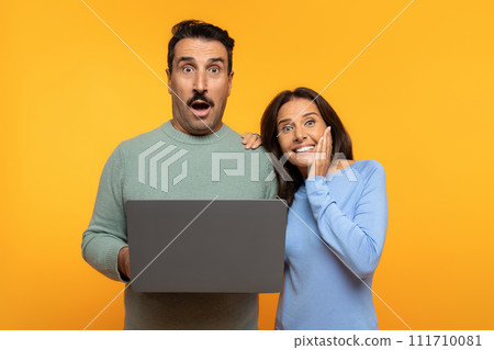 Shocked european senior man and woman exhibit excited expressions looking at laptop screen 111710081