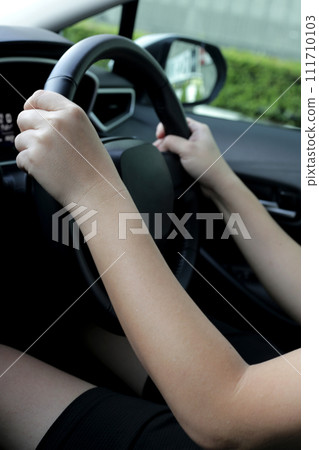 Hands holding steering wheel of car 111710103
