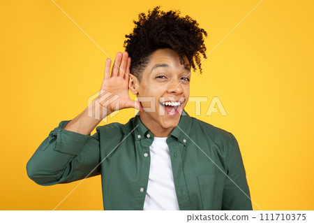 Curious interested african american man holding hand near ear Curious interested african american man holding hand near ear 111710375