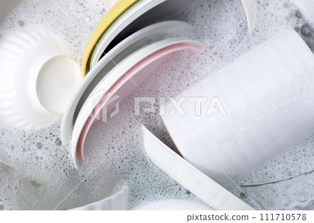 Dishes and bowls in water and bubbles of dishwashing liquid. Kitchen work Dishes and bowls in water and bubbles of dishwashing liquid. Kitchen work 111710578