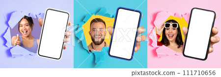 Three enthusiastic people giving thumbs up and cheerful smiles burst through colorful paper with smartphones 111710656