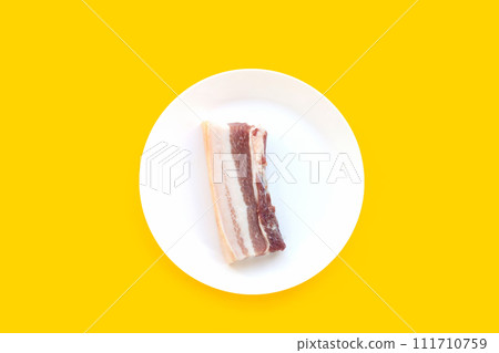 Streaky pork in white plate on yellow background. 111710759
