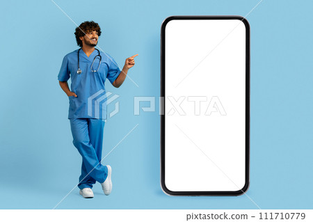 Doctor wearing medical uniform pointing at big phone 111710779