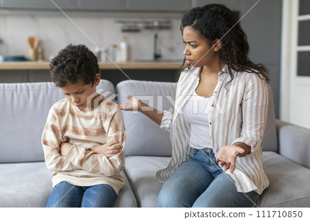 Angry african american mother scolding upset little son at home 111710850