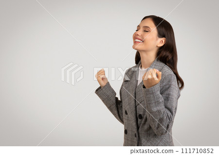 Joyful woman with clenched fists in triumph 111710852