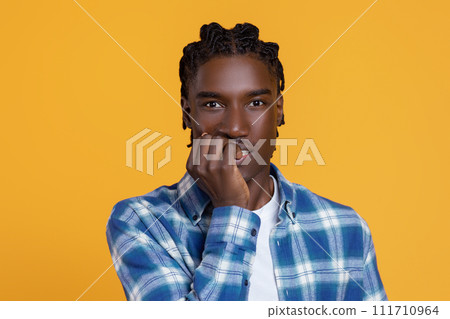 Scared young black man biting his nails and looking at camera 111710964