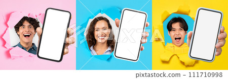 Glad millennial people popping through colorful paper, show smartphone with blank screen 111710998