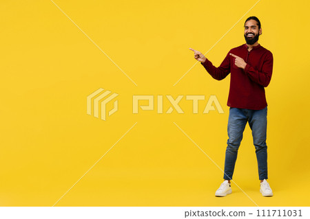 Cool positive young eastern guy pointing at blank space 111711031