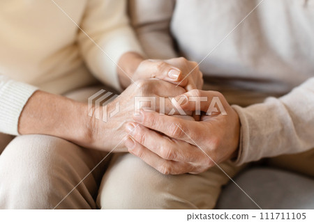 Old middle aged people holding hands close up view Old middle aged people holding hands close up view 111711105