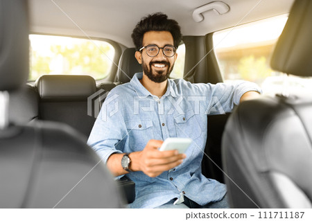 Indian man using cell phone, taking taxi Indian man using cell phone, taking taxi 111711187