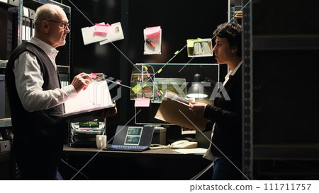 Law agents read witness statements to connect the dots in solving criminal case, using classified documents to find the missing puzzle piece. Professional investigators clandestine operation. Law agents read witness statements to connect the dots in solving criminal case, using classified documents to find the missing puzzle piece. Professional investigators clandestine operation. 111711757