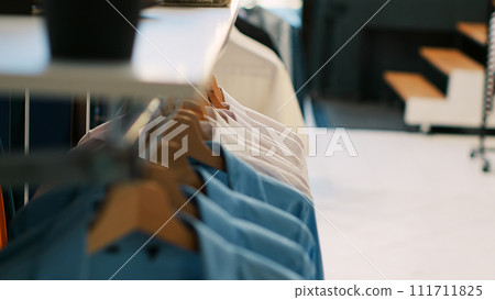 Empty shopping centre with casual and formal wear, retail shop with fashionable clothes and accessories on hangers and racks. Clothing store filled with new fashion collection waiting for customers. 111711825