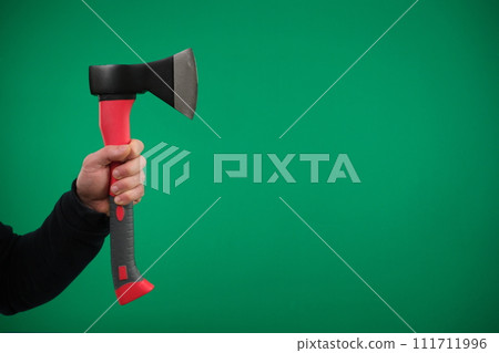 Male hand holding an axe with wooden handle. High quality advertising Green background chromakey copy space 111711996