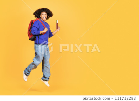 Joyful Young Black Traveller Guy With Backpack And Passport Jumping In Air 111712288
