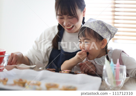 Parents and children making sweets 111712310