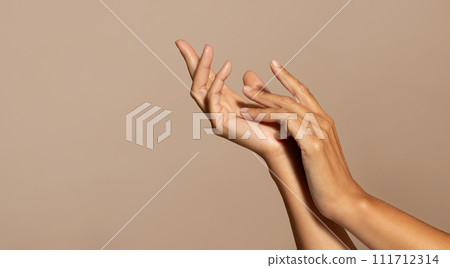 Hands of caucasian senior woman enjoy skin care, isolated on beige studio background, close up Hands of caucasian senior woman enjoy skin care, isolated on beige studio background, close up 111712314