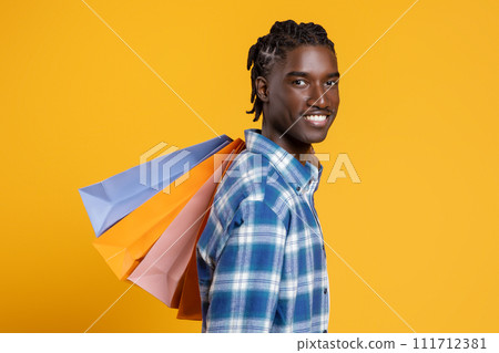Portrait Of Happy Cheerful Black Man Holding Lots Of Bright Shopping Bags 111712381