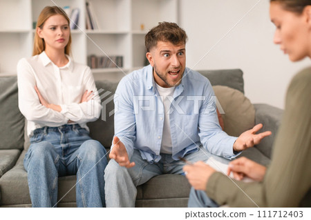 Aggressive husband shouts in anger during tense therapy session indoor 111712403