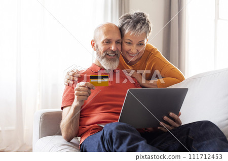 Online Shopping. Happy Senior Spouses Using Laptop And Credit Card At Home 111712453