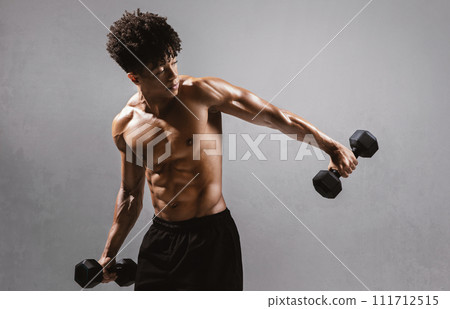 shirtless sportsman holding weights flexing strong arms on gray backdrop 111712515