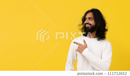Cool positive young eastern guy pointing at copy space 111712652