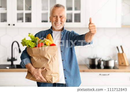 Happy Elderly Man Holding Paper Bag With Groceries And Showing Thumb Up Happy Elderly Man Holding Paper Bag With Groceries And Showing Thumb Up 111712843