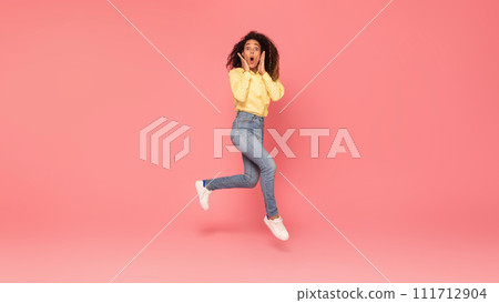 Surprised black woman jumps, touches cheeks, excited on pink backdrop Surprised black woman jumps, touches cheeks, excited on pink backdrop 111712904
