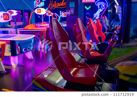 Racing arcade machines inside neon lit shopping 111712919