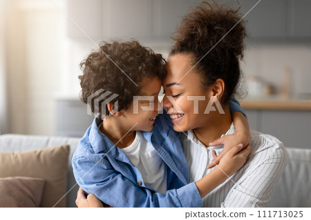 Black mother and son sharing tender nose-to-nose moment 111713025