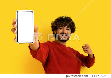 Positive eastern man showing smartphone with blank screen 111713039