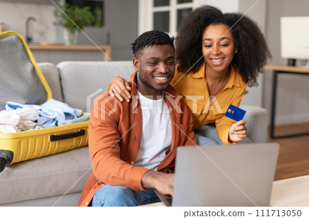 african couple using laptop and credit card booking tour indoor african couple using laptop and credit card booking tour indoor 111713050