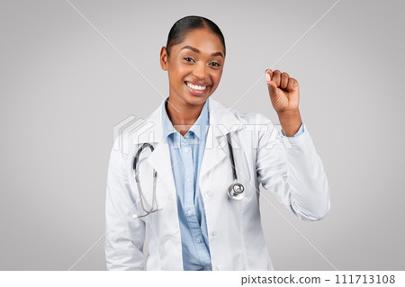 Glad young black lady doctor show pill capsule, recommends treatment Glad young black lady doctor show pill capsule, recommends treatment 111713108